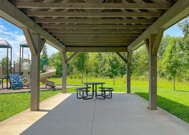 a view of swimming pool with a table and chairs in patio
