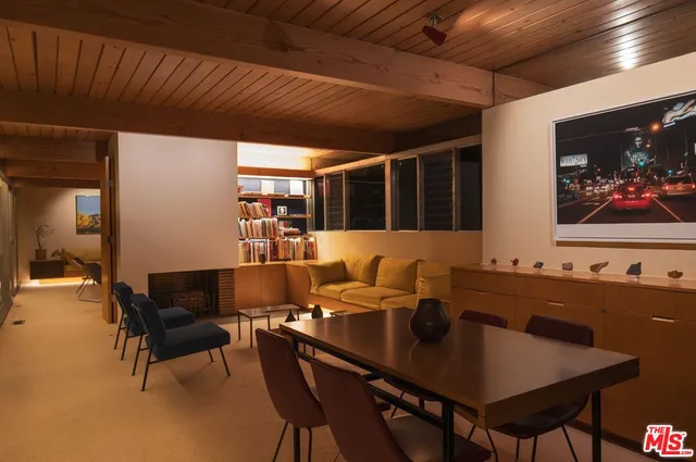 a room with table chairs and a potted plant