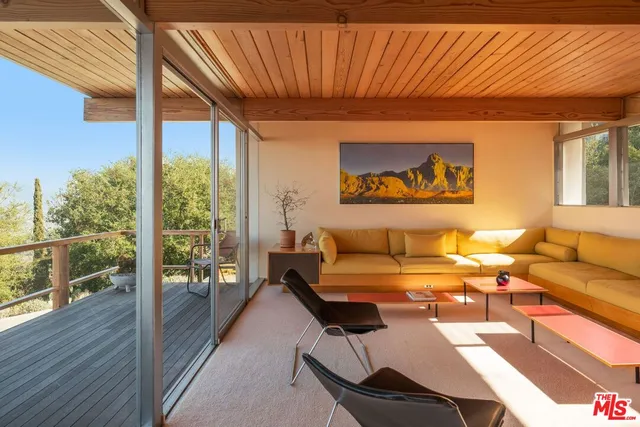a living room with furniture and floor to ceiling windows
