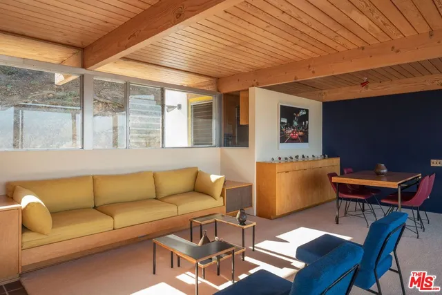 a living room with furniture a rug and a book shelf