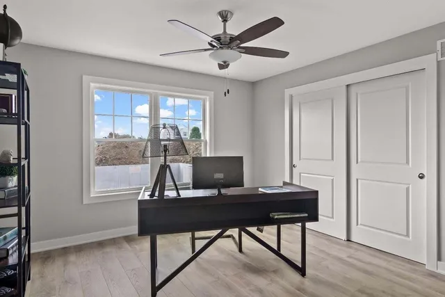 a view of a workspace with furniture and a window