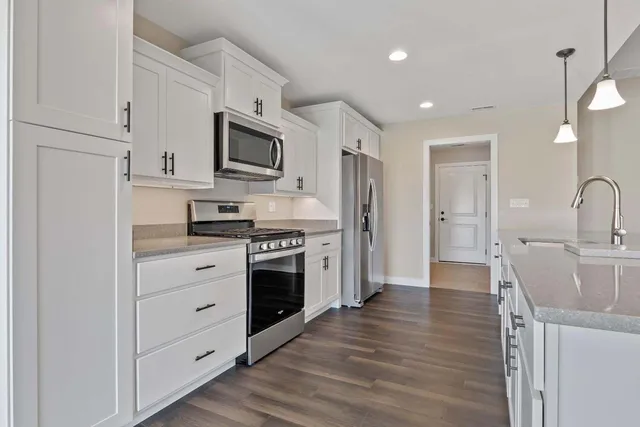 a kitchen with stainless steel appliances a stove microwave and refrigerator
