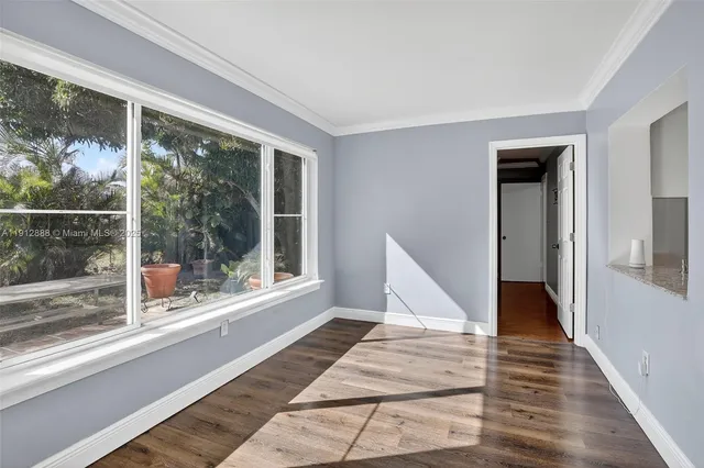 a view of a room with wooden floor and furniture