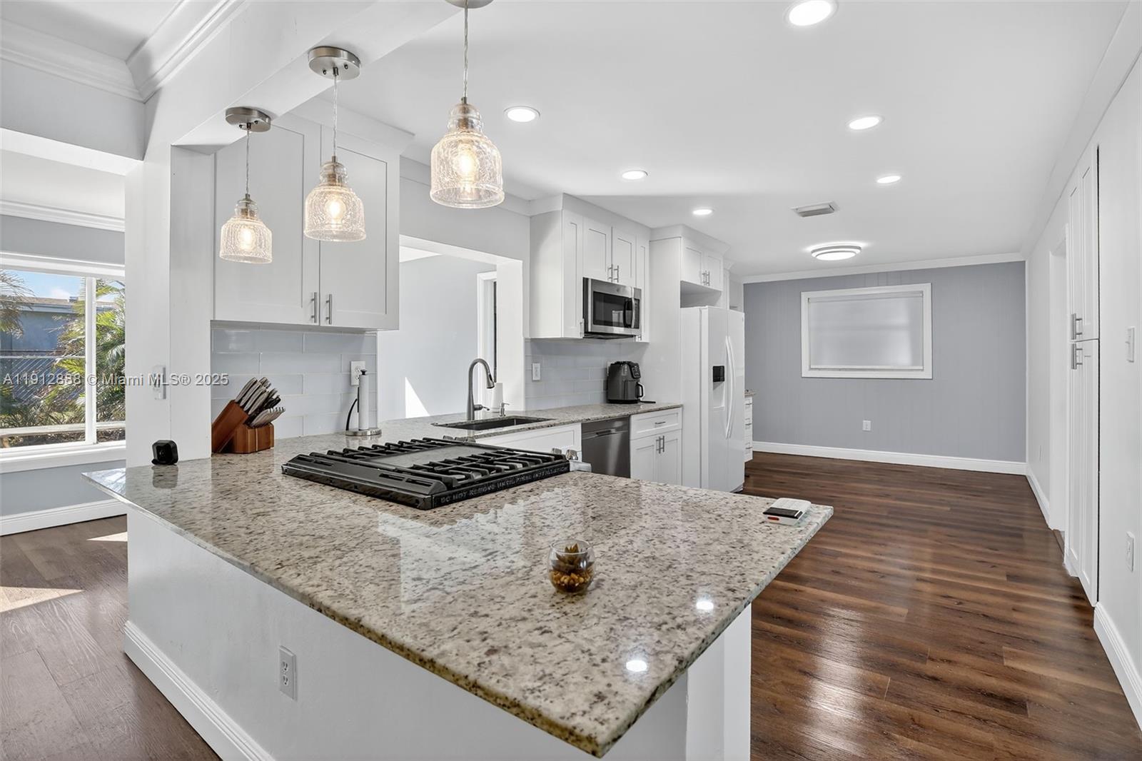 7920 Alhambra Boulevard Miramar, FL 33023 - Photo 15 of 38 a kitchen with kitchen island granite countertop a stove and a sink