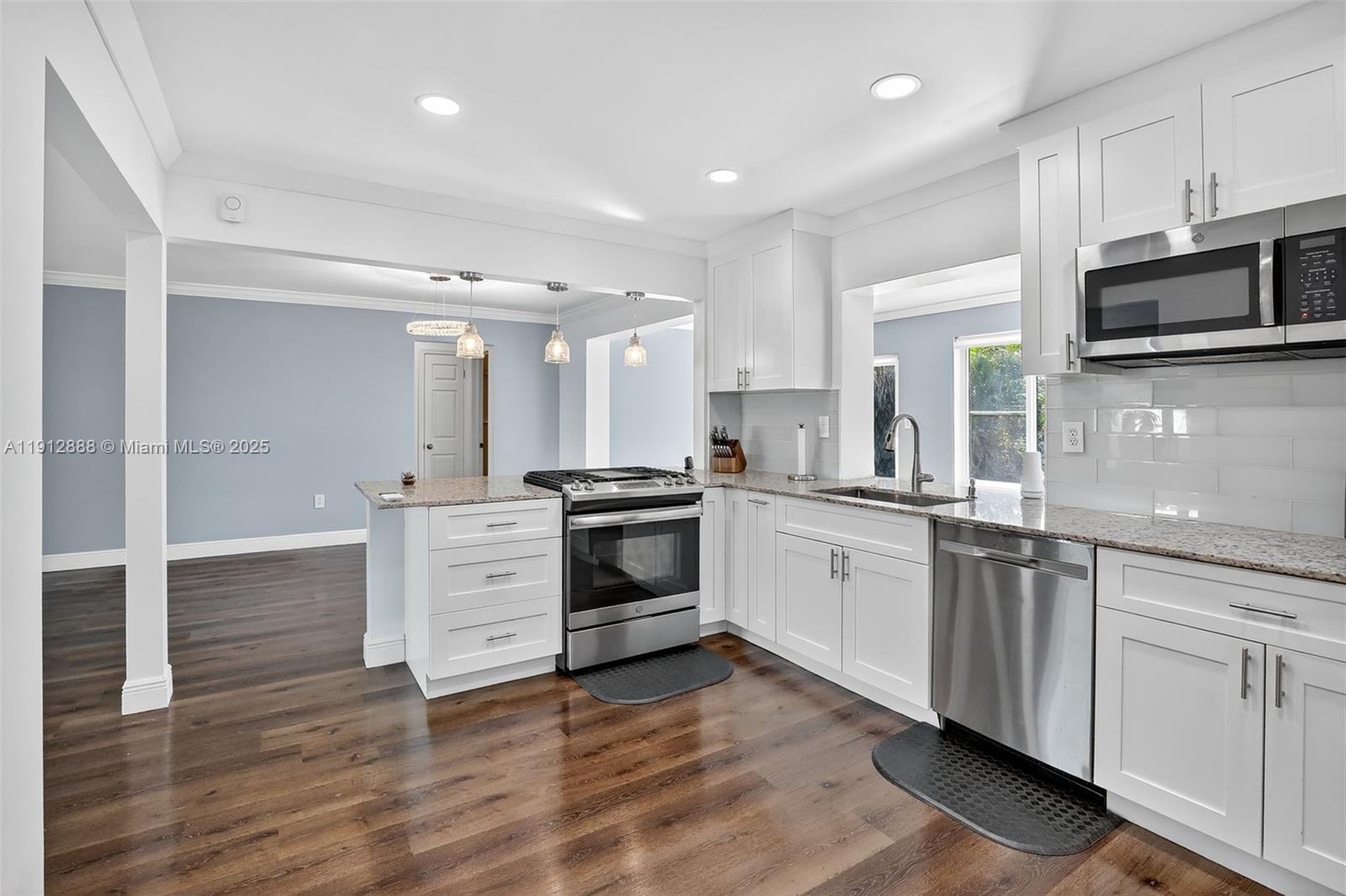 7920 Alhambra Boulevard Miramar, FL 33023 - Photo 16 of 38 a kitchen with stainless steel appliances white cabinets and a wooden floor