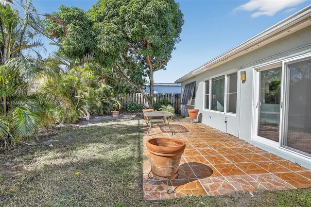 a view of a house with backyard and sitting area
