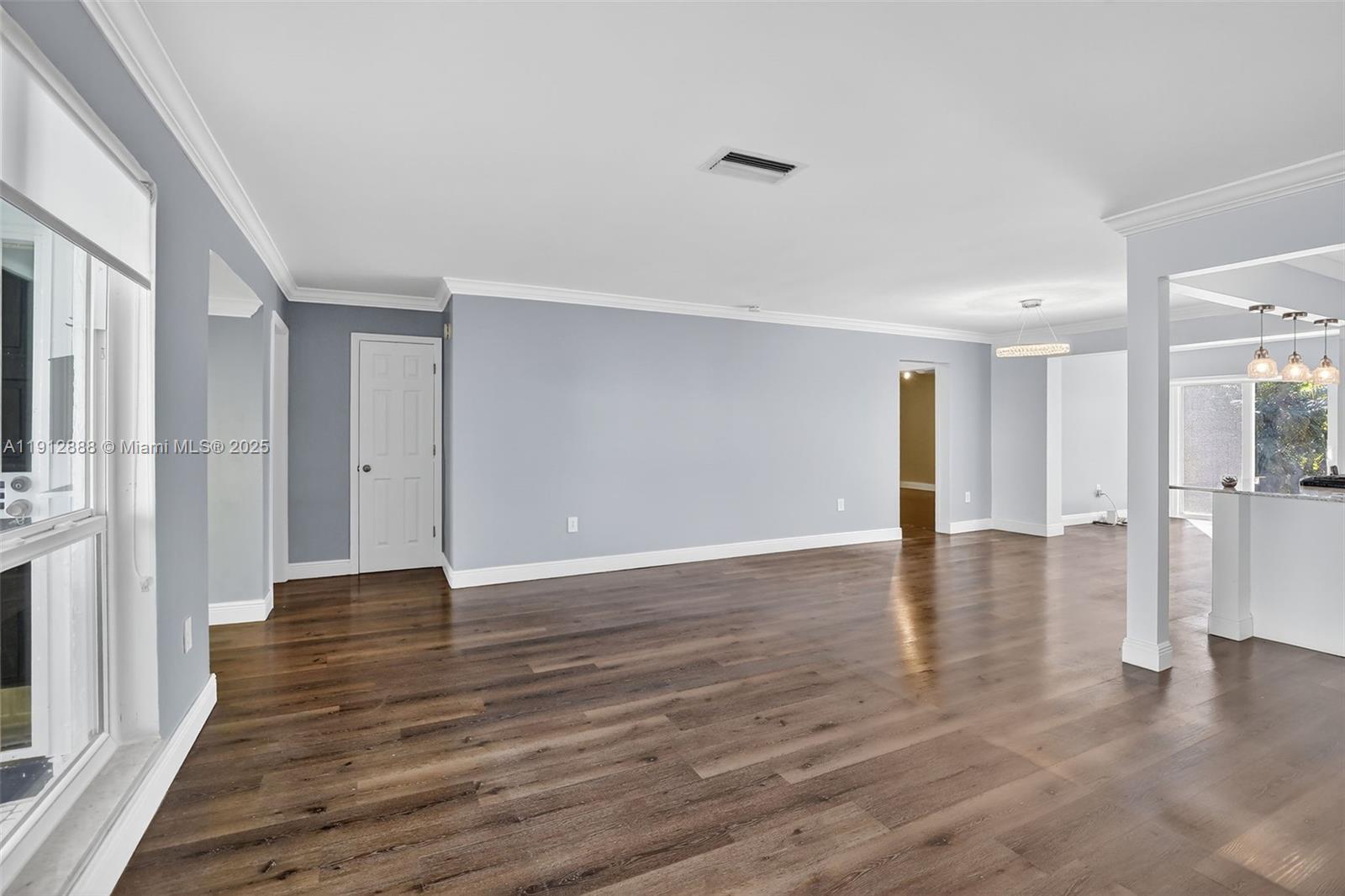 7920 Alhambra Boulevard Miramar, FL 33023 - Photo 7 of 38 a view of an empty room with wooden floor and a window