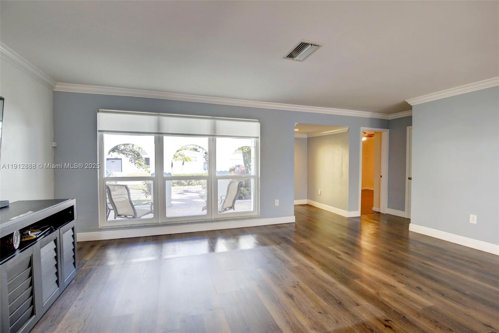 7920 Alhambra Boulevard Miramar, FL 33023 - Photo 8 of 38 a view of an empty room with wooden floor and a window
