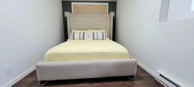 a bed sitting in a bedroom next to a window