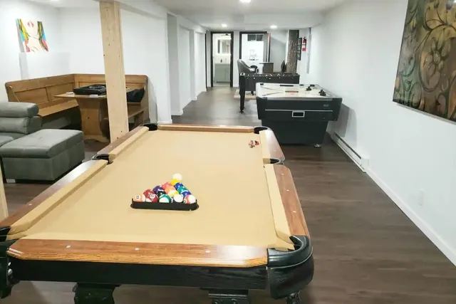 a living room with a table chairs and a refrigerator
