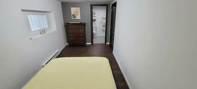a view of a hallway with wooden floor and closet