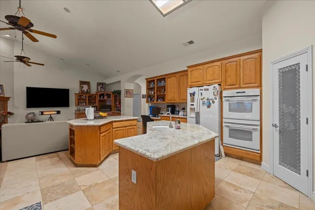 a kitchen with stainless steel appliances granite countertop a sink a stove counter space and cabinets