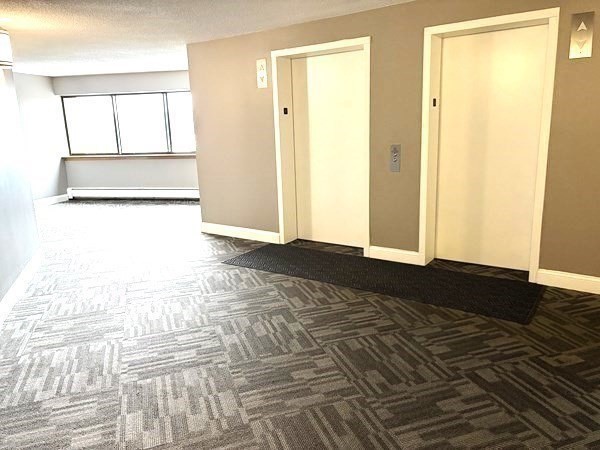 151 Coolidge Avenue, Unit 613 Watertown, MA 02472 - Photo 13 of 16 a view of a bedroom with wooden floor and a bathroom