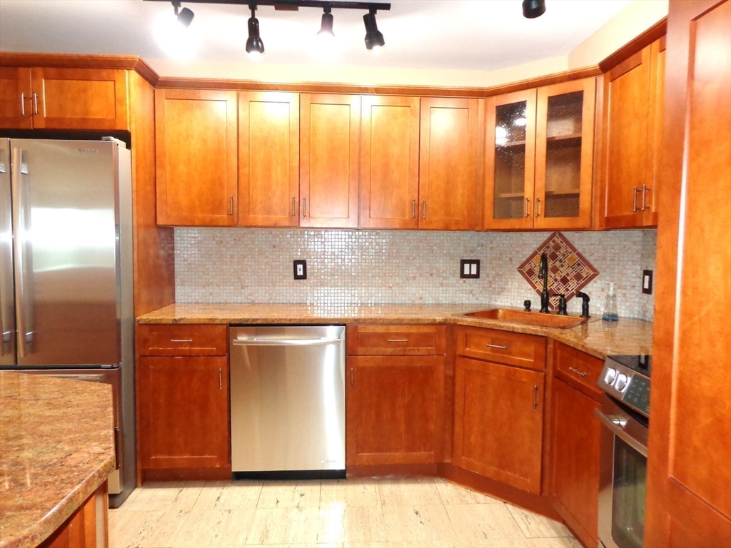 151 Coolidge Avenue, Unit 613 Watertown, MA 02472 - Photo 3 of 16 a kitchen with stainless steel appliances granite countertop a sink and a refrigerator
