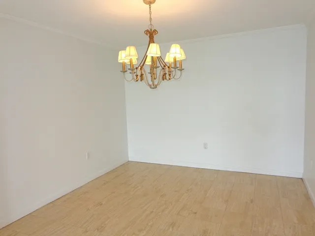 a view of a room with wooden floor and chandelier