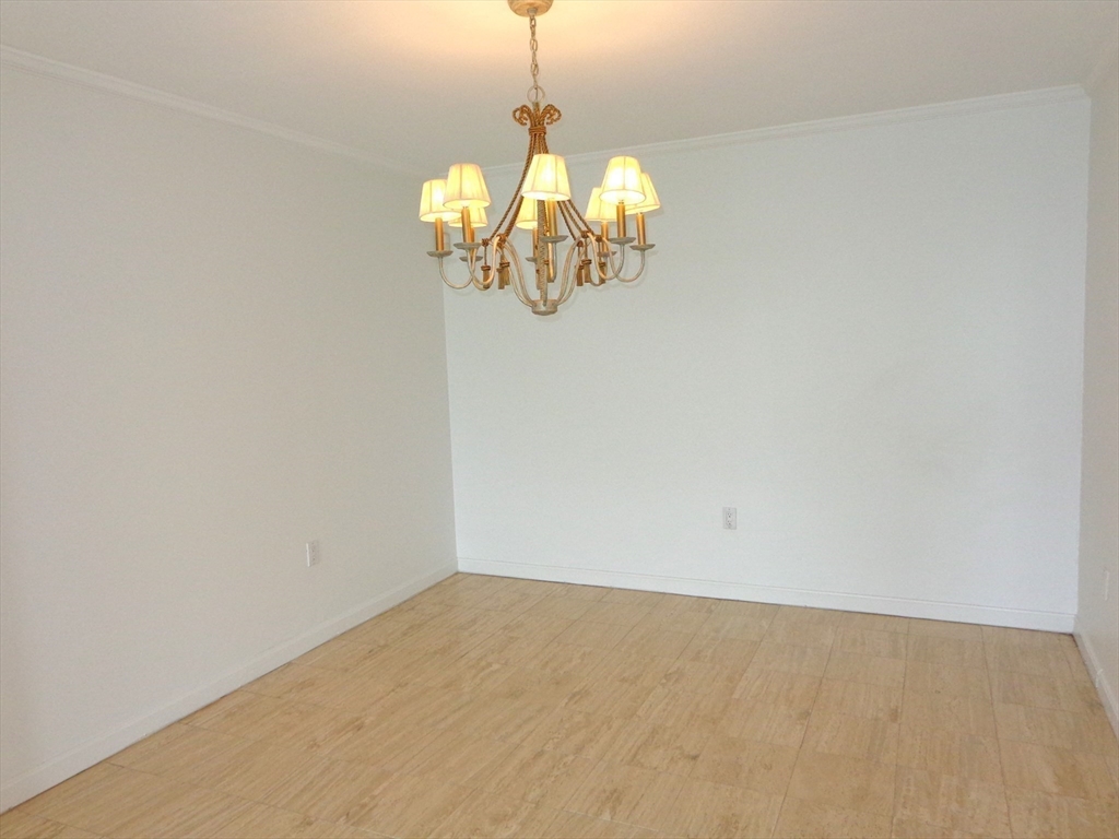 151 Coolidge Avenue, Unit 613 Watertown, MA 02472 - Photo 7 of 16 a view of a room with wooden floor and chandelier