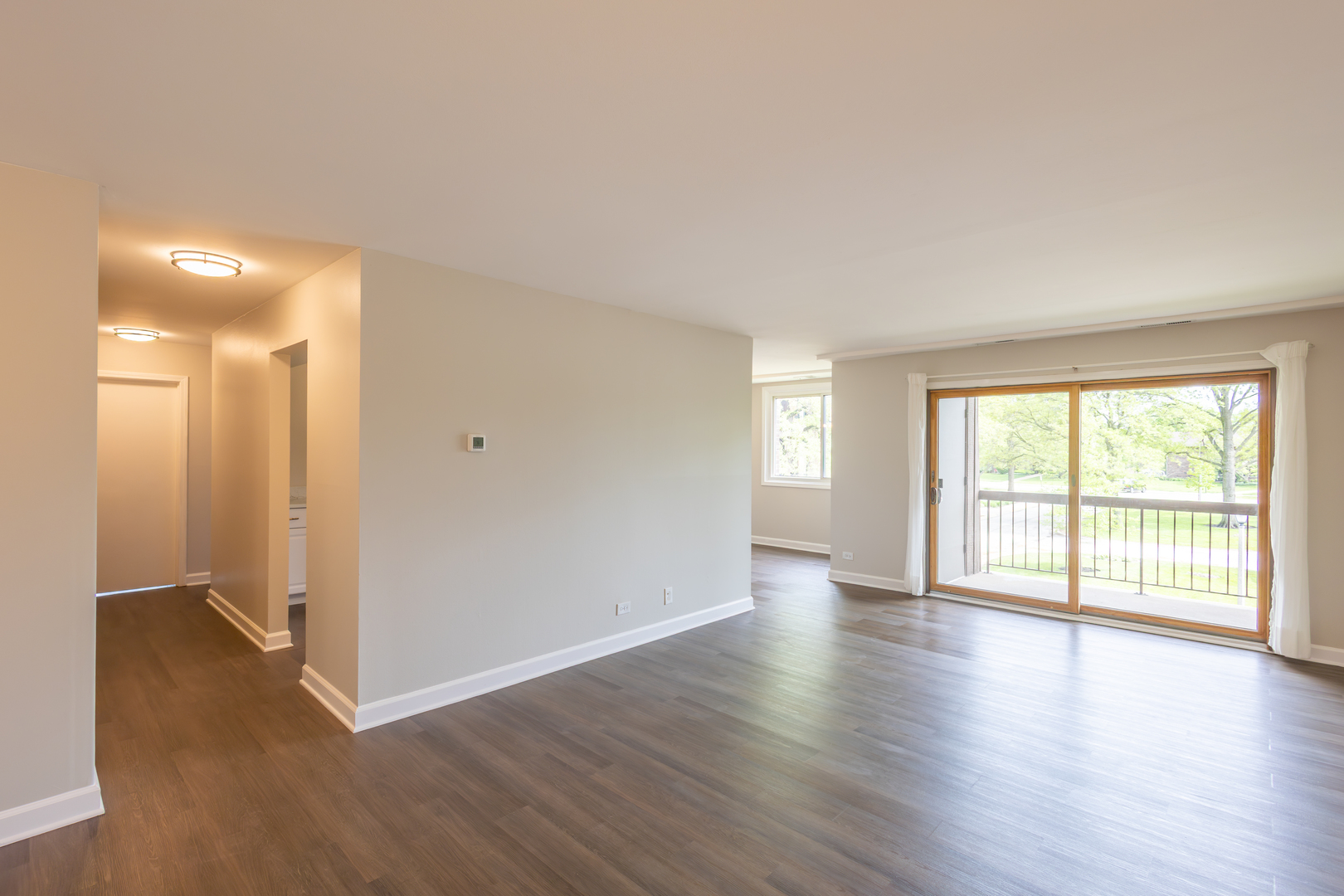 450 Raintree Court, Unit 2B Glen Ellyn, IL 60137 - Photo 3 of 28 an empty room with wooden floor and windows