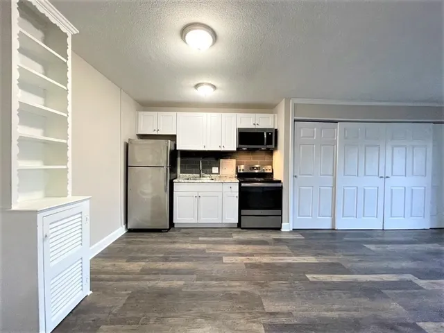 a kitchen with a refrigerator and a stove