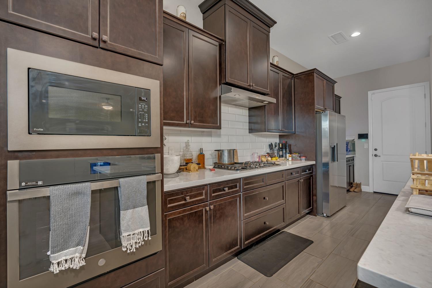 1053 Beaver Pond Loop Madera, CA 93636 - Photo 18 of 81 a kitchen with stainless steel appliances granite countertop a stove a sink and a microwave