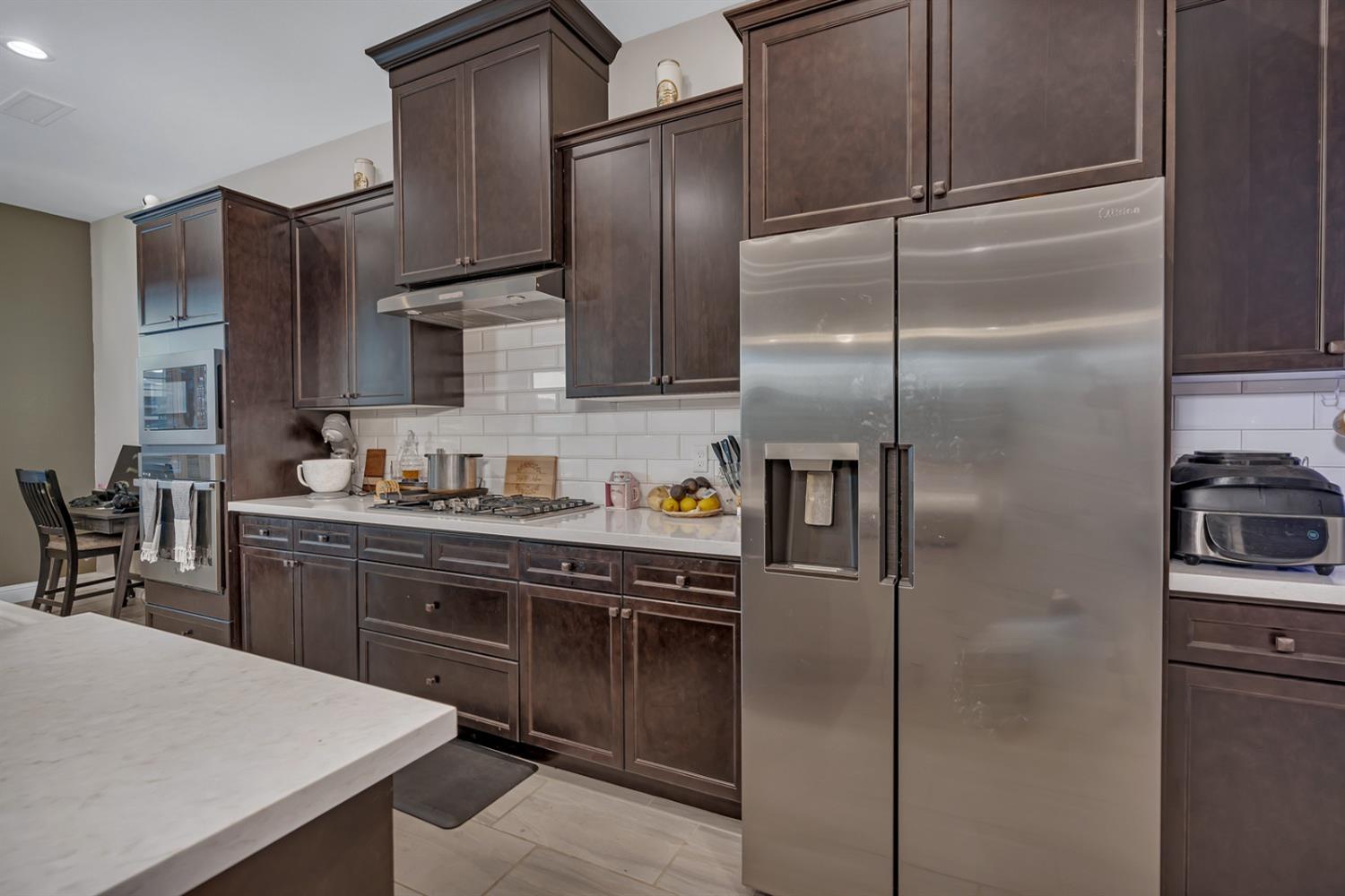 1053 Beaver Pond Loop Madera, CA 93636 - Photo 19 of 81 a kitchen with stainless steel appliances granite countertop a refrigerator and a sink
