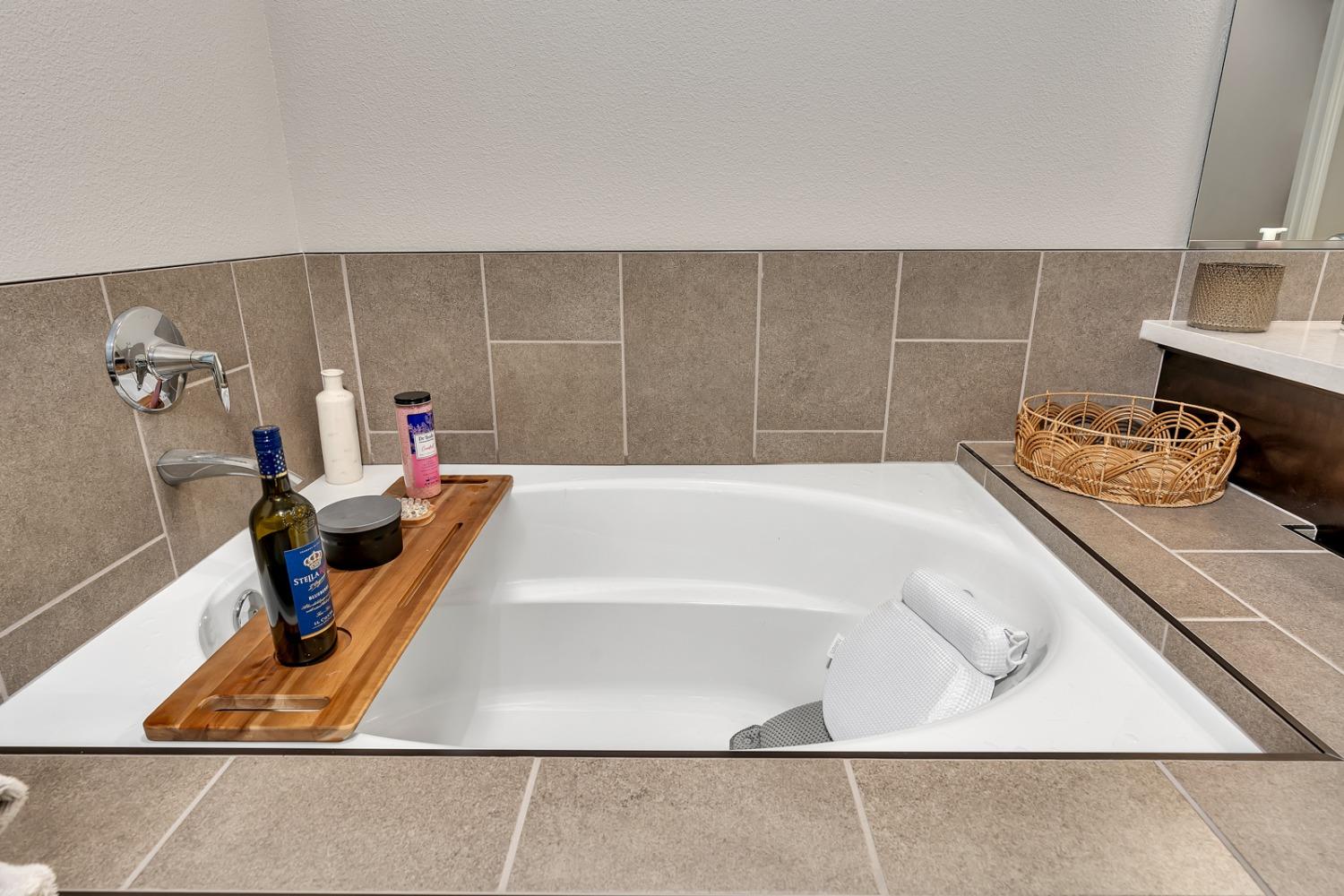 1053 Beaver Pond Loop Madera, CA 93636 - Photo 33 of 81 a bath tub sitting next to a white wooden cabinet
