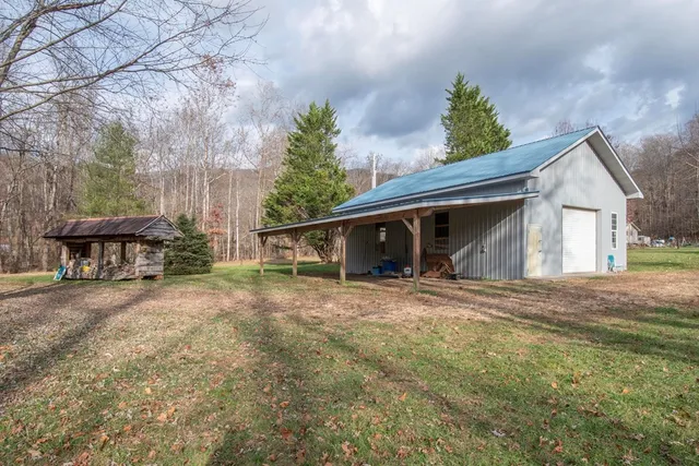a view of a house with backyard and trees