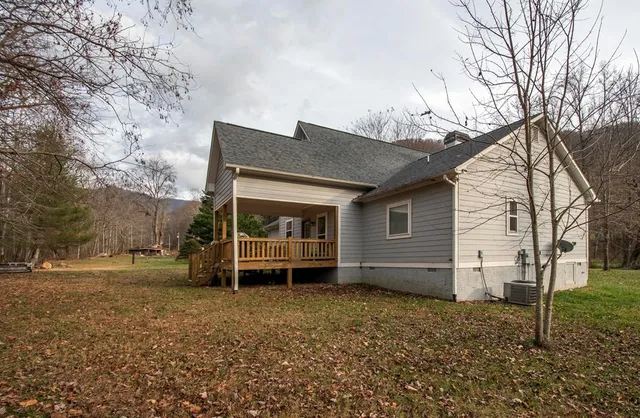a view of a house with a yard and wooden fence