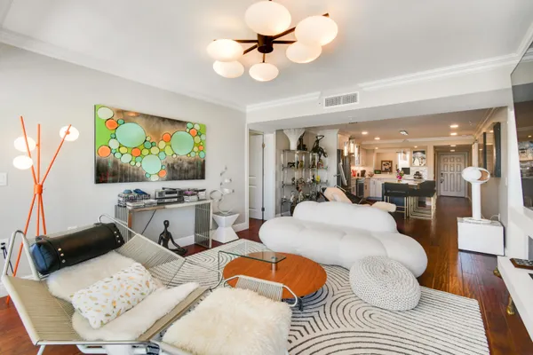 a living room with furniture a flat screen tv and a dining table with wooden floor