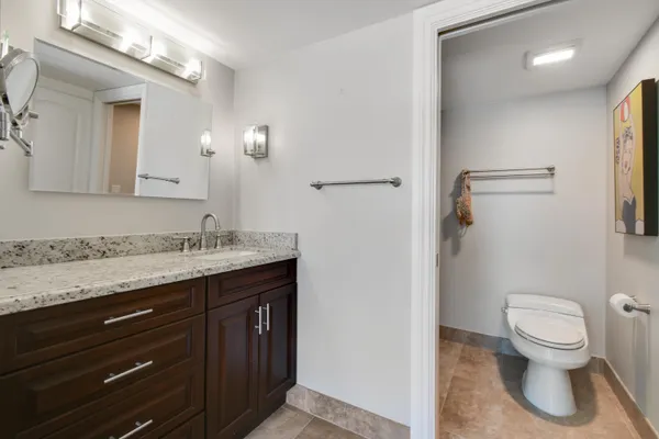 a bathroom with a granite countertop sink toilet and shower