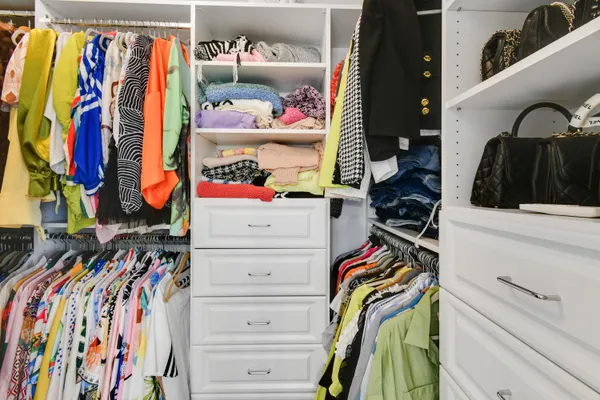 a view of walk in closet with clothes and shoes