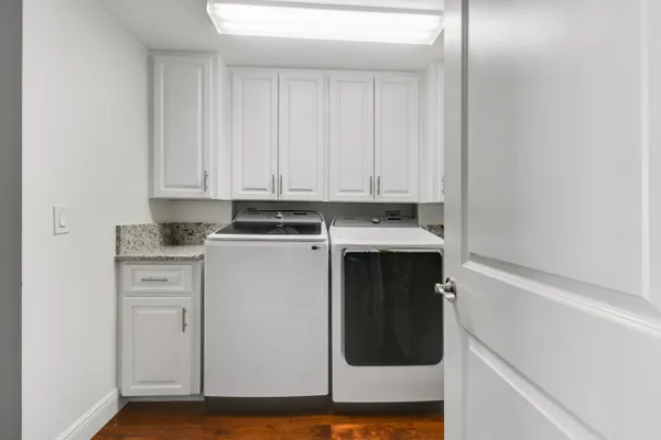 a utility room with wooden floor washer and dryer