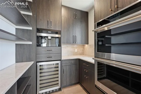 a kitchen with granite countertop stainless steel appliances and wooden floor