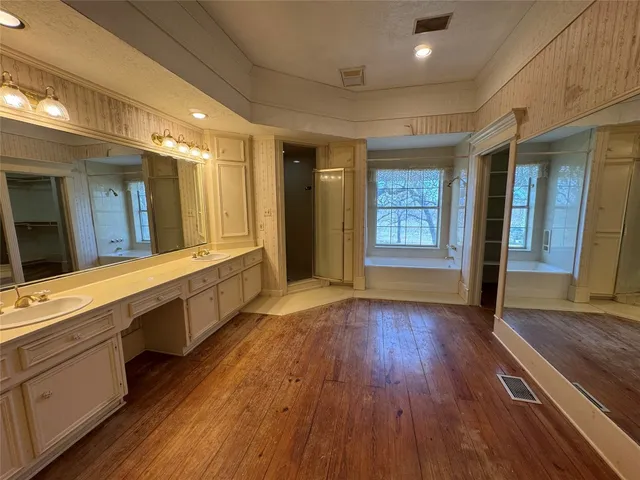 a spacious bathroom with a granite countertop sink and a large mirror