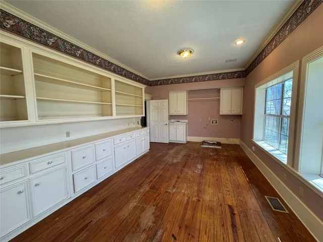a view of a kitchen with wooden floor and electronic appliances