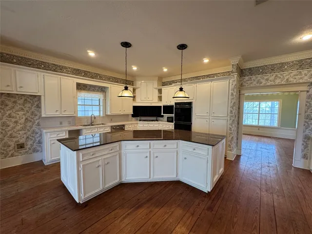 a kitchen with granite countertop a sink and cabinets