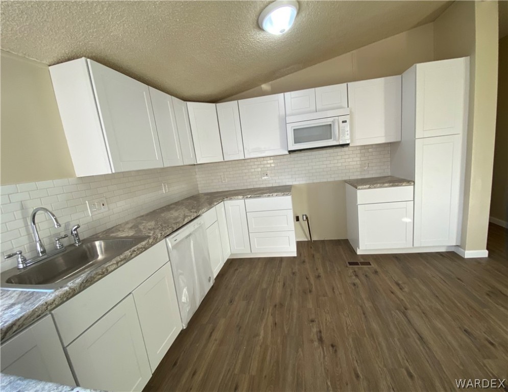 5272 Cove Road Golden Valley, AZ 86413 - Photo 8 of 24 a kitchen with wooden floors and white cabinets