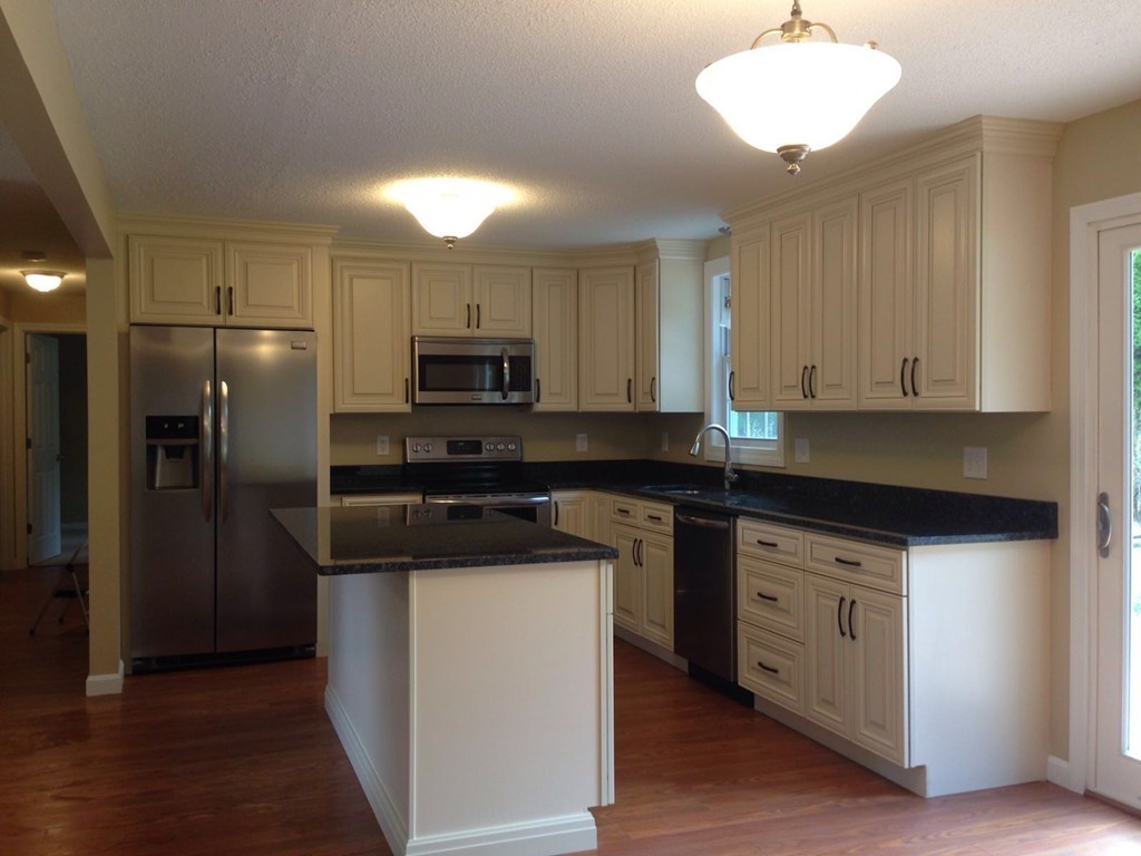 132 Benjamin Road Shirley, MA 01464 - Photo 3 of 9 a kitchen with stainless steel appliances granite countertop a refrigerator a stove a sink and white cabinets with wooden floor