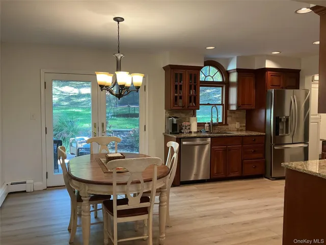 a kitchen with a table chairs refrigerator and microwave
