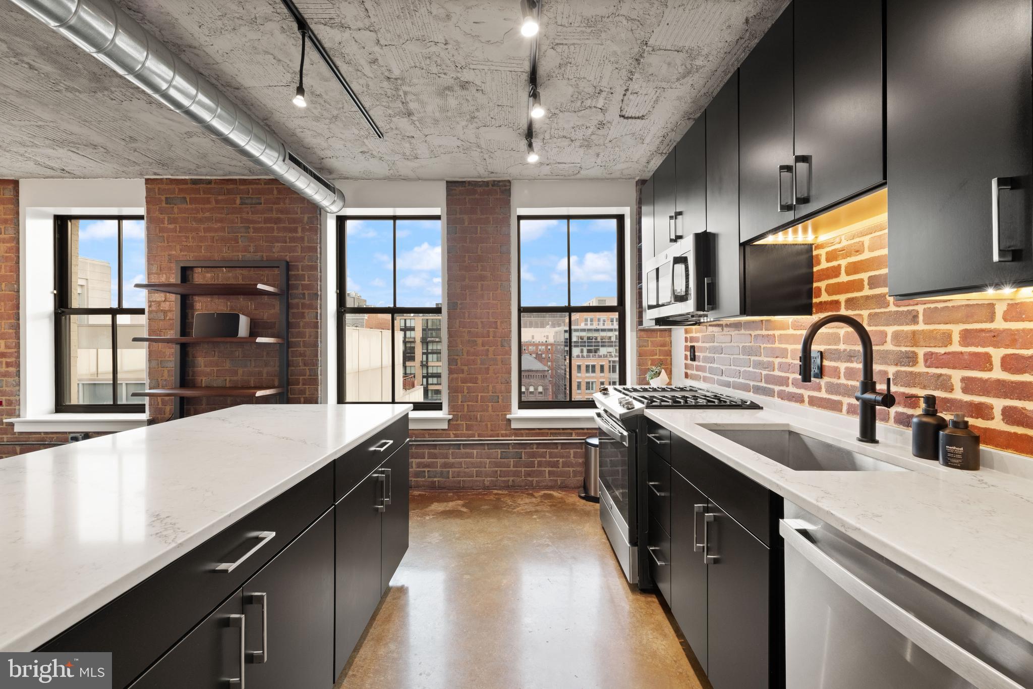 916 G St. Northwest, Unit 903 Washington, DC 20001 - Photo 13 of 65 a large kitchen with a large counter top a sink a stove and a refrigerator