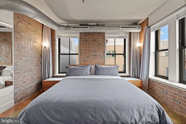 a spacious bedroom with a large bed and wooden floor