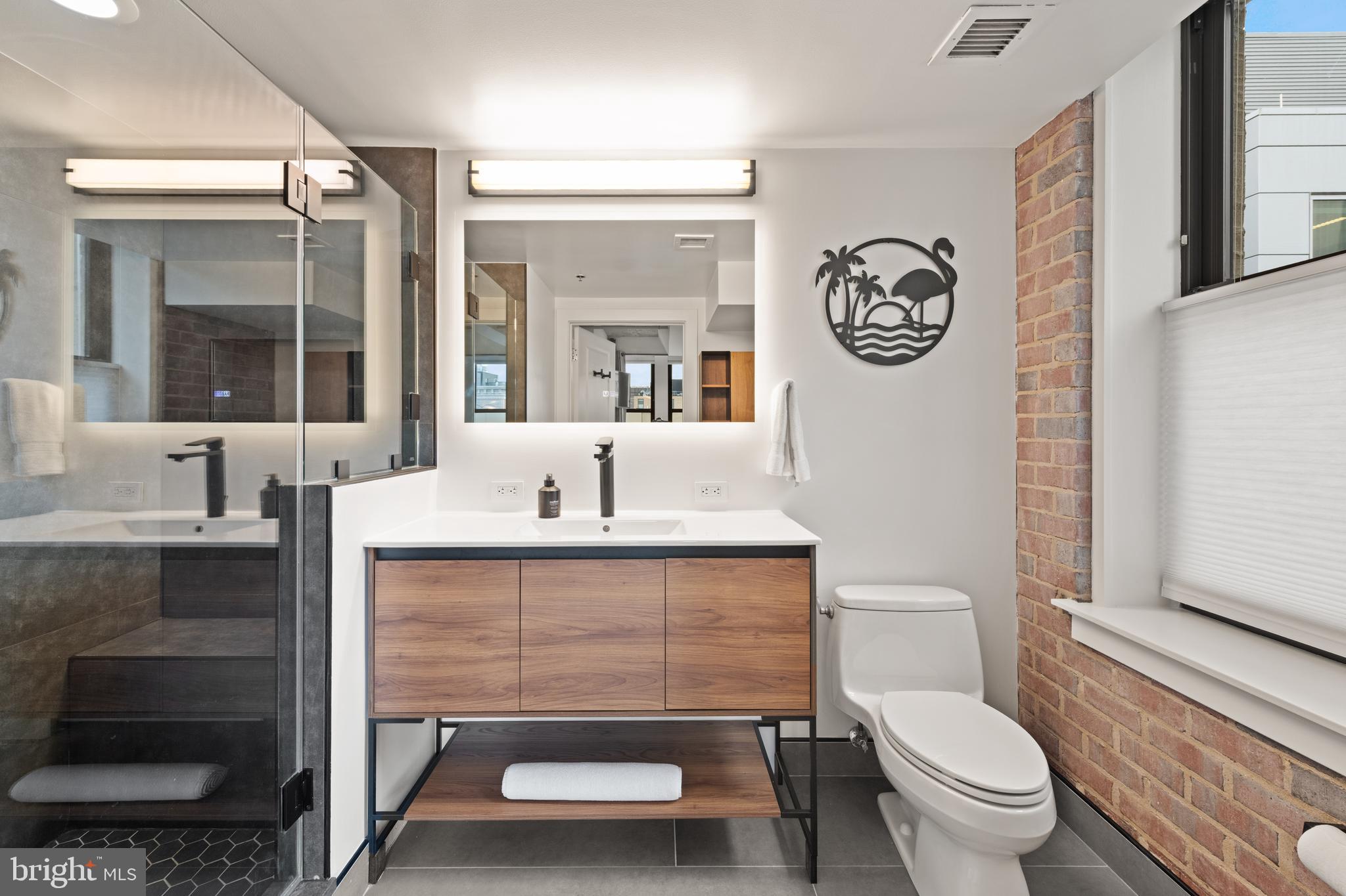 916 G St. Northwest, Unit 903 Washington, DC 20001 - Photo 23 of 65 a bathroom with a toilet a sink and a mirror