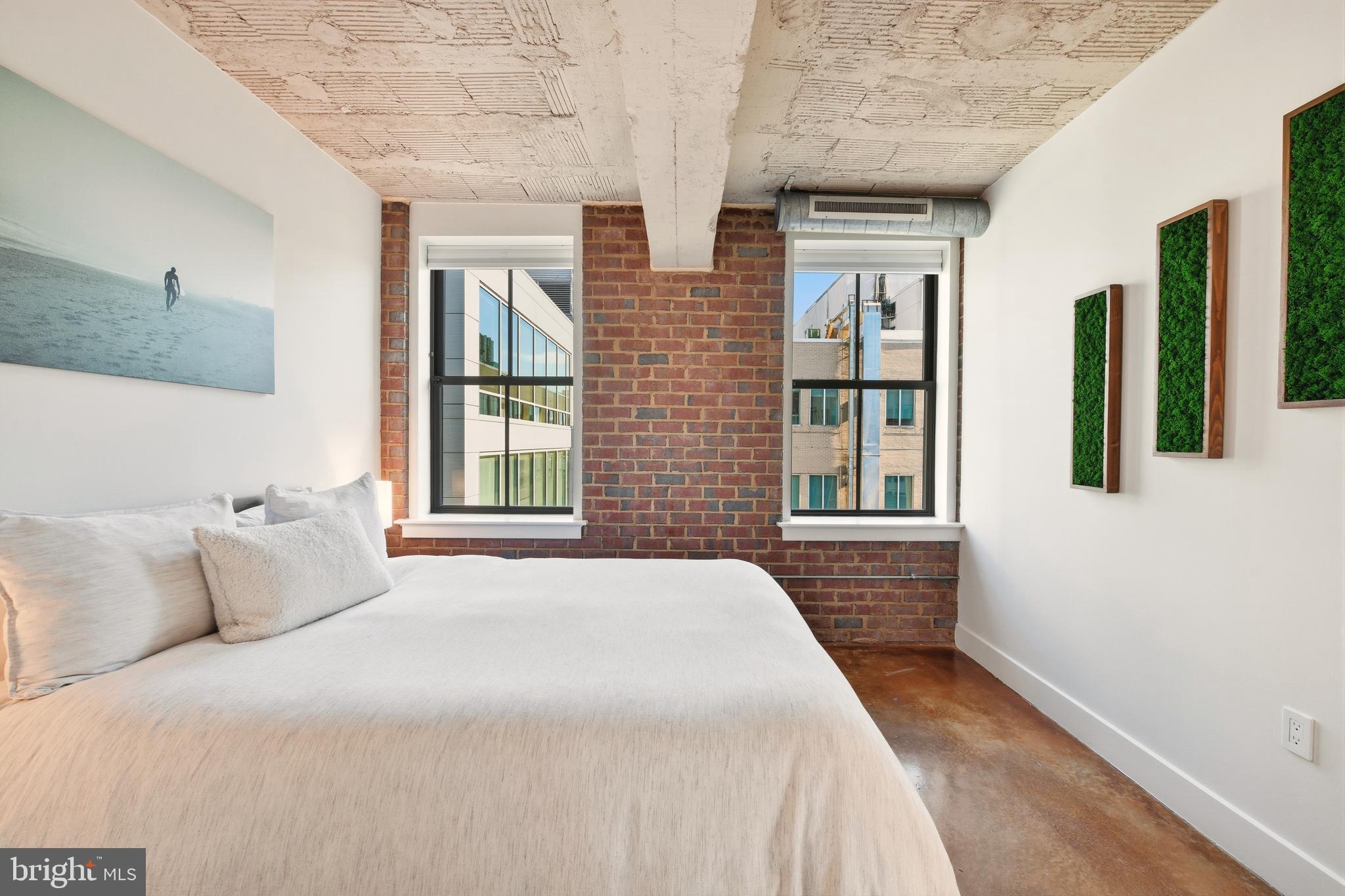 916 G St. Northwest, Unit 903 Washington, DC 20001 - Photo 28 of 65 a spacious bedroom with a large bed and two windows