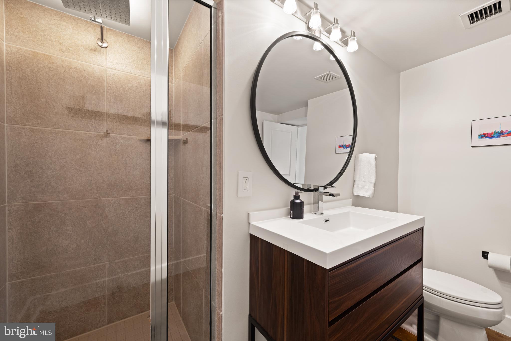 916 G St. Northwest, Unit 903 Washington, DC 20001 - Photo 34 of 65 a bathroom with a sink toilet and a mirror