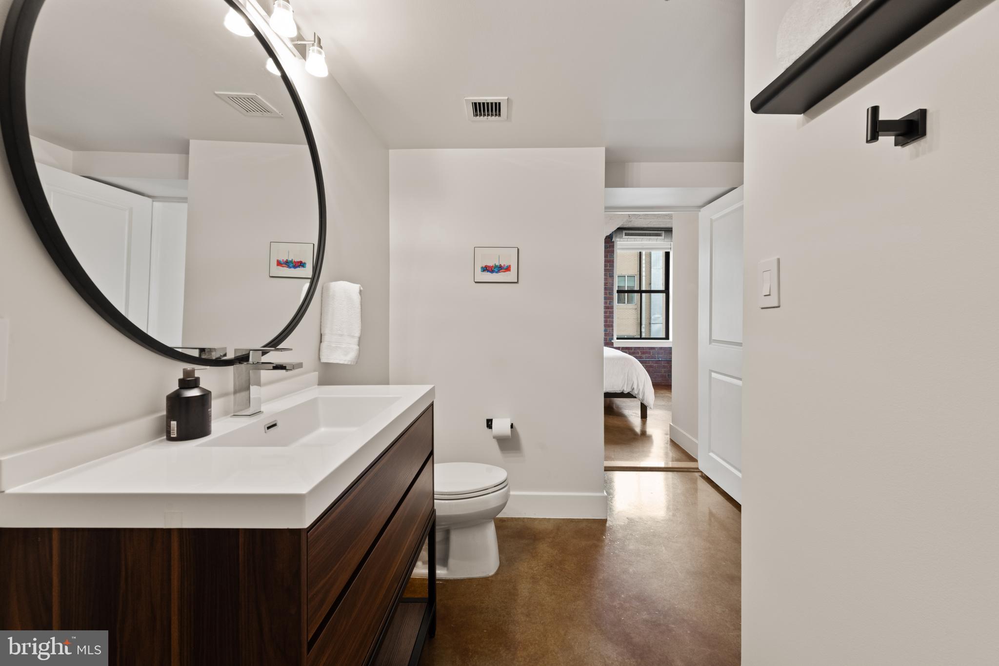 916 G St. Northwest, Unit 903 Washington, DC 20001 - Photo 35 of 65 a bathroom with a sink a toilet and a mirror