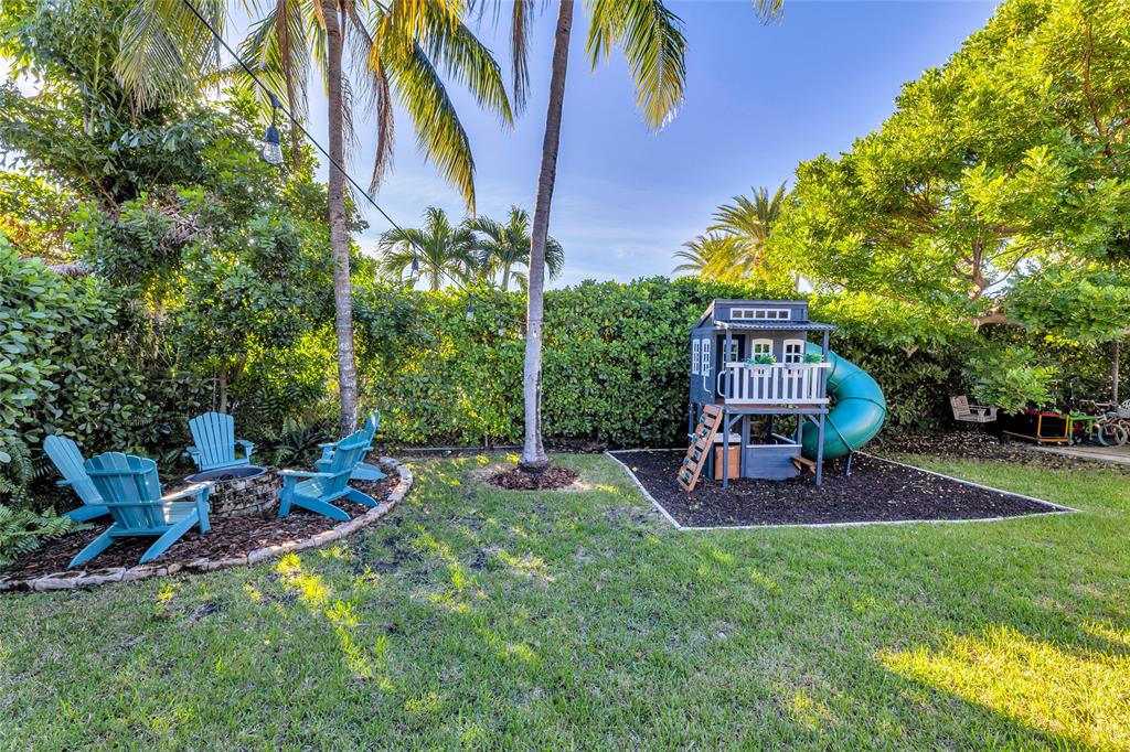 2 Mendota Lane Sea Ranch Lakes, FL 33308 - Photo 8 of 64 a view of a backyard with table and chairs and a slide