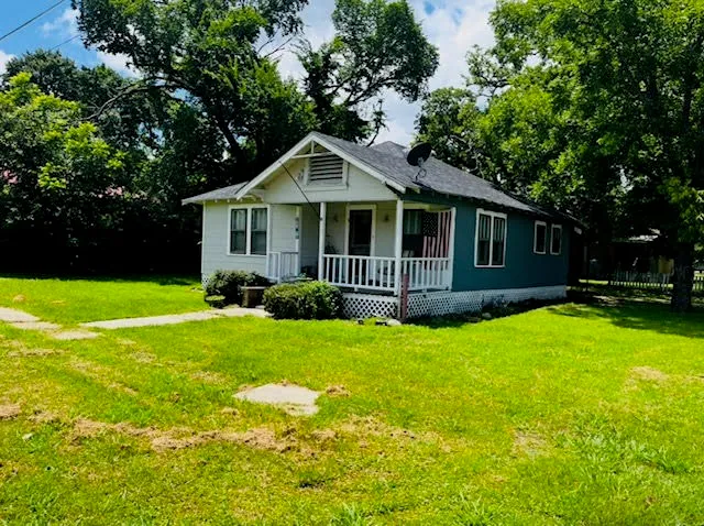 a front view of a house with yard and green space