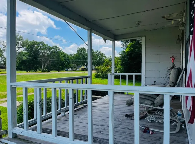 a view of a porch with wooden floor and furniture
