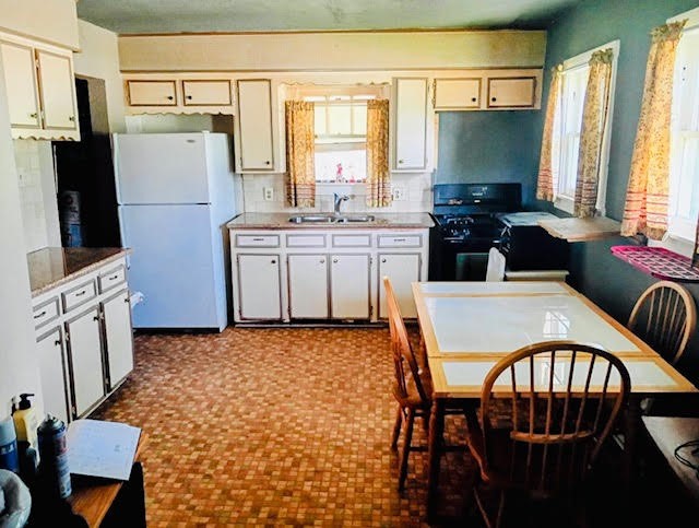 17066 Highway 36 Somerville, TX 77879 - Photo 15 of 16 a kitchen with stainless steel appliances granite countertop a stove a refrigerator a table and chairs