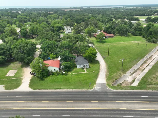 an aerial view of a house with a yard and lake view