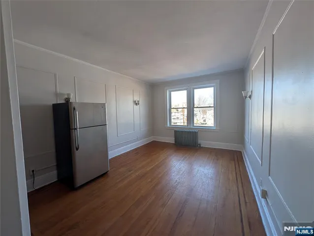 a view of a kitchen with wooden floor refrigerator and window